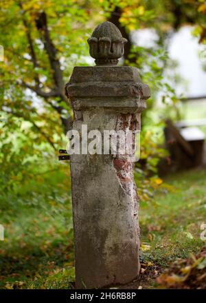 Laubsäule Vase auf Säule aus roten Ziegeln Garten mit hohen Pappelbäumen und einer Marmorvase auf einer Terrakotta-Säule Stockfoto