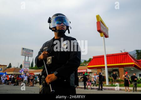 Tujena, CA, USA. 31st August 2020. Beamte der Polizeibehörde von Los Angeles stehen auf dem Foothill Blvd. Zwischen zwei gegnerischen Gruppen Wache, nachdem mehrere Auseinandersetzungen stattgefunden hatten. Auf eine wöchentliche Pro-Trump-Kundgebung trafen sich gegnerische Demonstranten. Quelle: Rise Images/Alamy Stockfoto