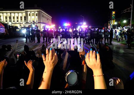 Kenosha, WI, USA. August 2020. In der Nacht des Kyle Rittenhouse stehen Demonstranten vor einer Polizeischnur vor dem Kenosha-Gerichtsgebäude, bei dem Schüsse während von Unruhen im Zusammenhang mit der Polizei auf Jacob Blake stattfanden. Stockfoto