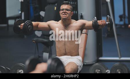 Arabischer Athlet verbessert seine Schultern durch Hantelzucht. Stockfoto