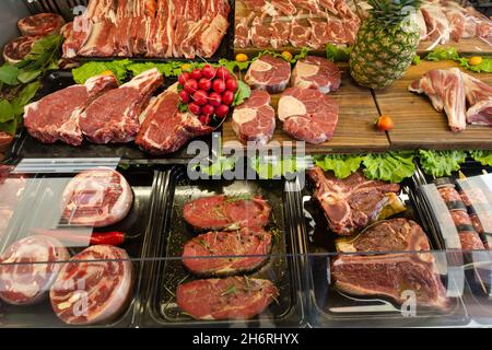 Gekühlte Vitrine einer Metzgerei mit einem großen Sortiment. Stockfoto