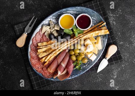 Verschiedene italienische Vorspeisen mit Grissini auf einem Teller. Stockfoto