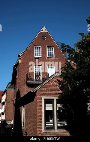 Vertikale Aufnahme von Ziegelgiebhäusern unter Sonnenlicht und blauem Himmel in Deutschland Stockfoto