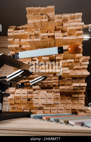 Schärfen Messer Prozess mit professionellen Spitzer mit Wetzstein in der Werkstatt Stockfoto