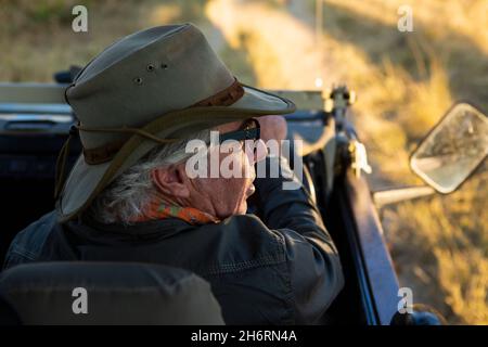 Ein Safariführer in einem Buschhut am Steuer eines Jeeps. Stockfoto