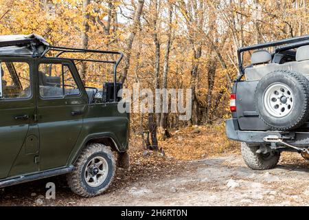 Zwei überdeckbare geländewagen mit Geländewagen im sowjetischen geländewagen auf unbefestigter Schotterstraße im Sommer bei Sonnenuntergang in der Morgensonne. Off Road Auto Berg Safari Abenteuer Stockfoto