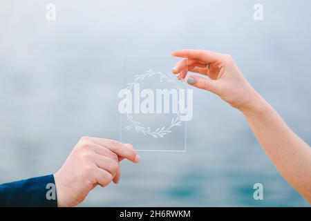 Männliche und weibliche Hand mit einem transparenten Bild, das einen Kranz zeigt Stockfoto
