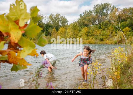 Zwei kleine Kinder waten im Sommer an windigen Tagen im See Stockfoto