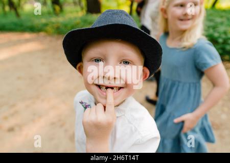 Nahaufnahme eines Jungen, der auf die Lücke in seinen Vorderzähnen zeigt Stockfoto