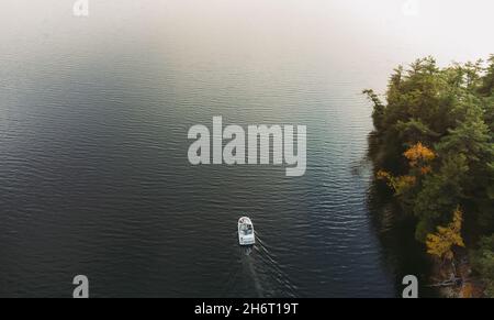 Luftaufnahme des Bootes auf dunklem Wasser des Sees in Ontario, Kanada. Stockfoto
