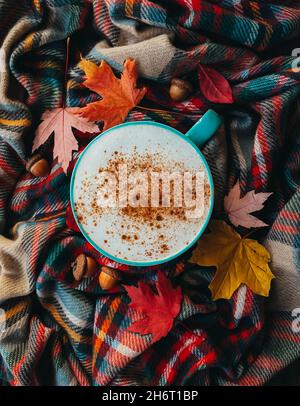Über dem Kopf von Kürbis Gewürz Latte auf karierten Herbst Schal mit Blättern Stockfoto