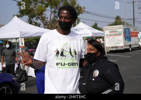AC Green Jr. (links) posiert mit dem weiblichen Polizeibeamten Scott aus Los Angeles während des Thanksgiving Grab and Go Drive-Thru der Los Angeles Dodgers Foundation Stockfoto