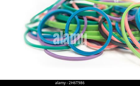 Haufen von Gummibändern oder elastischen Schlaufen in einer Vielzahl von Farben und Größen. Stationäre Bürobedarf zum Bündeln, Organisieren und Arbeiten mit Kunst. Nahaufnahme. Isolat Stockfoto