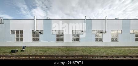 Modernes Industriegebäude mit installierten Rohren von Lüftungssystemen an der Fassade Stockfoto