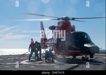 Besatzungsmitglieder an Bord des USCGC Stone (WMSL 758) führen Hubschrauberflugoperationen mit einer Luftmannschaft des taktischen Helicopter Interdiction Squadron der Küstenwache vor der Küste Floridas durch, 14. November 2021. Mit einzigartigen Behörden, einer breiten Jurisdiktion, flexiblen operativen Fähigkeiten und einem ausgedehnten Netzwerk nationaler und internationaler Partnerschaften fördert die Küstenwache die nationale Sicherheit, den wirtschaftlichen Wohlstand und den globalen Einfluss auf die Seefahrt. (USA Foto der Küstenwache von Shannon Kearney, dem Kleinoffizier der 2. Klasse) Stockfoto