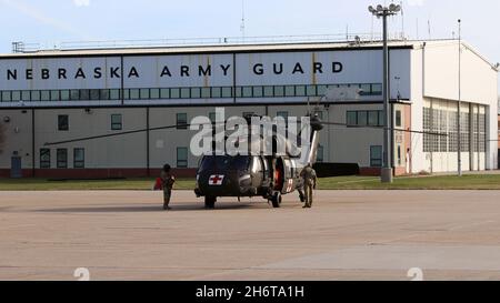 Sgt. Larry Vancura und Sgt. Scott Honnens, Crew-Chefs, die in der Nebraska Army National Guard dienen, bereitet einen UH-60 Blackhawk-Hubschrauber in Lincoln, Nebr., vor, um Luftbrandbekämpfungsfähigkeiten zur Unterstützung von Feuerwehrleuten zu bieten, die am 15. November 2021 das Buffalo Creek-Waldfeuer im Westen Nebraskas bekämpfen. Der Gouverneur von Nebraska, Pete Ricketts, leitete die Aktivierung von zwei UH-60 Blackhawk-Hubschraubern mit Wassereimern und 9 Soldaten der Army National Guard für die Mission, nachdem ein Feuer ausging und sich am Vortag schnell über 2,000 Hektar verbrannten. Es war die vierte Aktivierung von Nebraska Army National Stockfoto