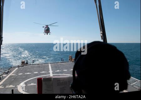 Besatzungsmitglieder an Bord des USCGC Stone (WMSL 758) führen Hubschrauberflugoperationen mit einer Luftmannschaft des taktischen Helicopter Interdiction Squadron der Küstenwache vor der Küste Floridas durch, 14. November 2021. Mit einzigartigen Behörden, einer breiten Jurisdiktion, flexiblen operativen Fähigkeiten und einem ausgedehnten Netzwerk nationaler und internationaler Partnerschaften fördert die Küstenwache die nationale Sicherheit, den wirtschaftlichen Wohlstand und den globalen Einfluss auf die Seefahrt. (USA Foto der Küstenwache von Shannon Kearney, dem Kleinoffizier der 2. Klasse) Stockfoto