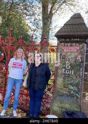 Liverpool, Großbritannien. November 2021. Dozentin Holly Tessler (rechts) und ihre Schülerin Susan stehen vor dem Eingangstor zum Strawberry Field . Mehr als 50 Jahre nach dem Aufbruch der Beatles würdigt ein neuer Studiengang in ihrer Heimatstadt Liverpool den immensen Einfluss der weltberühmten Musikgruppe auf Kultur und Gesellschaft. (To dpa: 'New Beatles study course: 'Fab Four changed culture') Credit: Benedikt von Imhoff/dpa/Alamy Live News Stockfoto