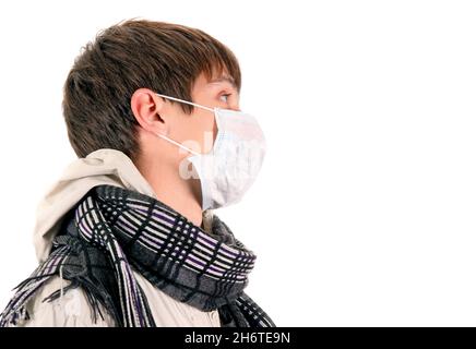 Junger Mann in der Grippe-Maske schaut weg auf den weißen Hintergrund Stockfoto