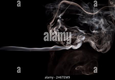 Abstrakte Rauchbewegung auf dunklem Hintergrund. Konzept des alternativen Nikotinrauchens. Verschwommenes Bild warmer, getönter Rauch. Elektronische Zigarette. Verdampfer. Weichfokus. Streaming. Stockfoto