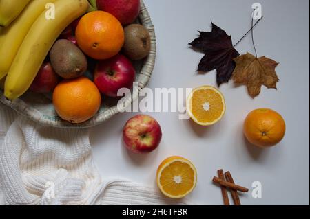 Flache Obstlage in der Schüssel, Pullover und trockene Blätter auf weißem Hintergrund Stockfoto