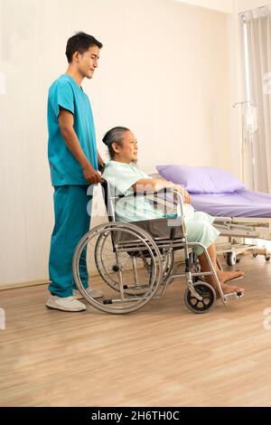 Glücklich asiatische ältere ältere Männer auf Rollstuhl genießen Aufenthalt Krankenhaus Ärztliche Betreuung neben älteren Patien Stockfoto