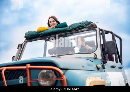 Konzept Sommerurlaub Familienurlaub, verwirklichen Traum. Glücklicher Mann und glückliche Frau reisen mit dem Auto in einem Cabrio zum Meer. Stockfoto