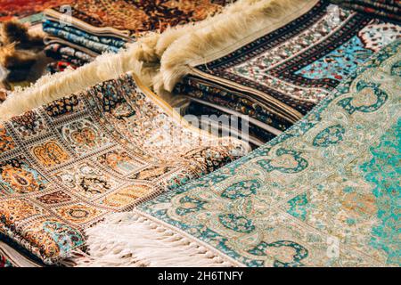 Nahaufnahme von traditionellen orientalischen Teppichen und Teppichen als Hintergrund mit Kopierfläche. Bunte Zierteppiche im Teppichladen. Beliebt Stockfoto