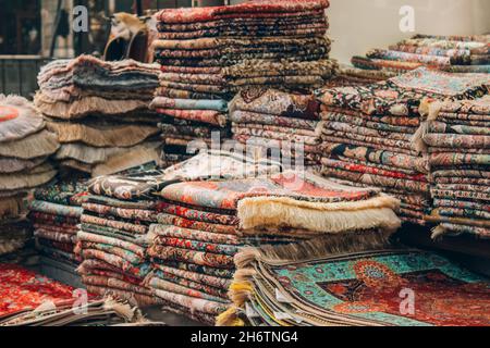 Teppichgeschäft mit einer Vielzahl von traditionellen orientalischen Teppichen und Teppichen mit dekorativen Elementen als Hintergrund mit Platz für Kopien. Beliebtes touristisches Souvenir Stockfoto