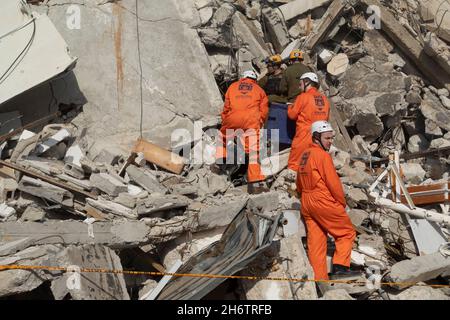 Israelische Soldaten der Rettungseinheit des Home Front Command und Mitglieder des Zaka Disaster Victim Identification Teams laufen durch die Trümmer eines eingestürzten Gebäudes, während sie am 16. November 2021 in Tel Aviv, Israel, an einer Such- und Rettungsübung an einem großen Abrissplatz teilnehmen. Die Home Front-Übung simulierte Such- und Rettungsaktionen, die sich auf Szenarien vorbereiten, die Gebäude zerstören und Bürger aufgrund eines schweren Erdbebens oder massiver Raketeneinschläge einfangen könnten. Stockfoto