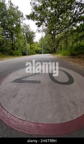 Der Park verfügt über eine breite Asphaltstraße mit einer Geschwindigkeitsbegrenzung von 20 km. Gestrecktes Zeichen in der Perspektive Stockfoto