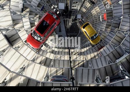 Wolfsburg, Deutschland. November 2021. Innenansicht eines Autoturms in der Autostadt, eines roten Passat und eines turmfarbenen T-Rocs im Auslieferungszentrum für Neuwagen, Vogelperspektive, am 11.11.2021 in Wolfsburg/Deutschland. â Credit: dpa/Alamy Live News Stockfoto