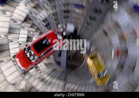 Wolfsburg, Deutschland. November 2021. Innenansicht eines Autoturms in der Autostadt, eines roten Passat und eines turmfarbenen T-Rocs im Auslieferungszentrum für Neuwagen, dynamisch, unscharf, Vogelperspektive, am 11.11.2021 in Wolfsburg/Deutschland. â Credit: dpa/Alamy Live News Stockfoto