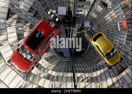 Wolfsburg, Deutschland. November 2021. Innenansicht eines Autoturms in der Autostadt, eines roten Passat und eines turmfarbenen T-Rocs im Auslieferungszentrum für Neuwagen, Vogelperspektive, am 11.11.2021 in Wolfsburg/Deutschland. â Credit: dpa/Alamy Live News Stockfoto