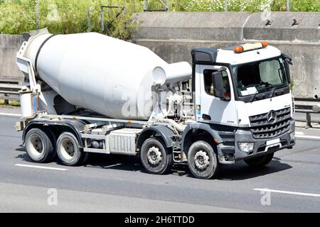 Seite & Vorderansicht weiß sauber Mercedes Lieferung LKW-Chassis Kabine mit bereit Mischung Beton Zement Mischtrommel Fahrer auf UK Autobahn fahren ausgestattet Stockfoto