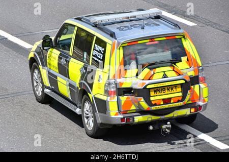 Luftaufnahme und Rückansicht Verkehrsoffizier Fahrer im gut sichtbaren Streifenwagen Signale auf Spurwechsel entlang der Autobahn M25 Essex England Großbritannien Stockfoto