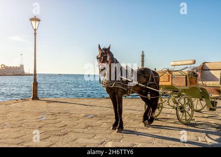 Der alte Hafen von Chania Stadt mit Pferdekutsche und Leuchtturm auf Kreta, Griechenland. Stockfoto