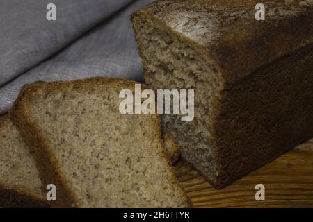 Brot aus braunem, biologischem Roggenbrot auf schwarzem Hintergrund. Zwei Scheiben Brotscheiben. Für Text platzieren. Banner für ein Designprojekt. Stockfoto