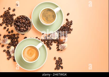 Kaffeeschokolade. Espresso mit Schaum oder Macchiato in kleinen Tassen, bestreute Kaffeebohnen und Pralinen. Blick von oben. Hochwertige Fotos. Speicherplatz kopieren Stockfoto