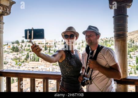 Ein touristisches Paar, das Selfie in der Alhambra mit Blick auf Granada, Andalusien, Spanien macht Stockfoto