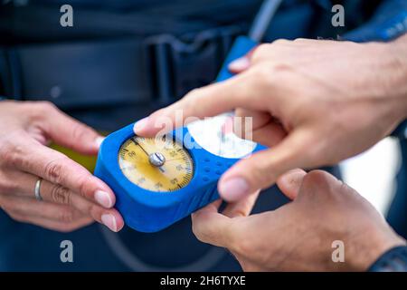 Mann erklärt, dass das Manometer zeigt, wie viel Luft im Tank beim Tauchen in Spanien ist Stockfoto