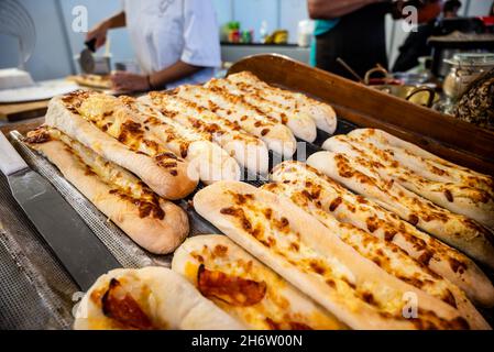 Langes Pizzabrot mit Käse und Chourico-Wurst, verkauft auf der Santa Iria Fair in Faro, Algarve, Portugal Stockfoto