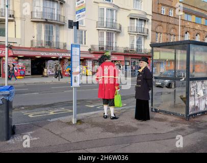 Everyday Hastings - das Warten auf den Bus an der Küste von Hastings kann eine lange Wartezeit sein Sussex England UK - ungewöhnliches seltsames, schrulliges Kleid aus der Zeit Stockfoto