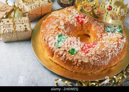 Roscon de reyes mit Creme- und weihnachtsschmuck auf einem Tisch. Kings Day Konzept spanische drei Könige Kuchen Stockfoto