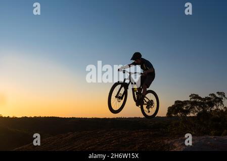 Ein junger Mountainbike-Fahrer bekommt bei einem Sprung auf dem Jubilee Oval Bikepark im Vorort Wahroonga in Sydney, New South Wales, Australien, noch etwas Luft Stockfoto