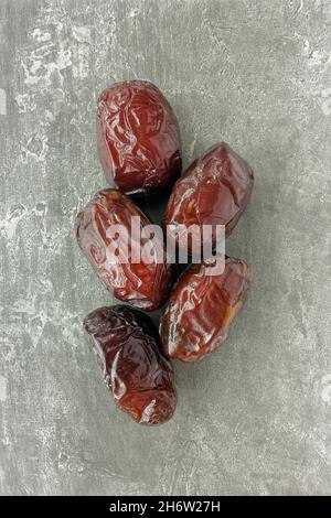 Kreatives Layout von großen, dicken und saftigen medjool-Datteln auf grauem Texturhintergrund mit Kopierraum. Stockfoto