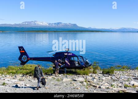 AKKAJAURE, SCHWEDEN - 4. AUGUST 2015: Touristen auf dem Weg zum Hubschrauber Stockfoto