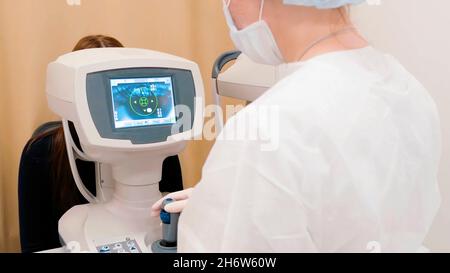 Nahaufnahme eines Arztes oder Augenarztes, der eine Augenuntersuchung an einem Patienten mit einem modernen Gerät durchführt. Stockfoto