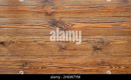 Holztisch aus lackiertem gebürstetem Holz. Texturierter Hintergrund aus Holz, Nahaufnahme mit Platz für Kopien. Holz mit goldenem Farbton. Stockfoto