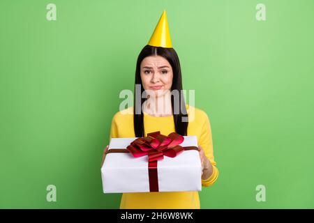 Portrait von attraktiven skeptischen Mädchen hält giftbox nicht wie unangenehme isoliert über grüne Farbe Hintergrund Stockfoto